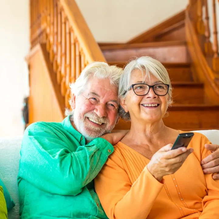 Couple of two happy seniors sitting on the sofa